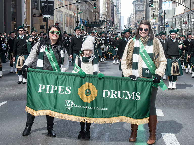 Students holding Pipes and Drums banner.